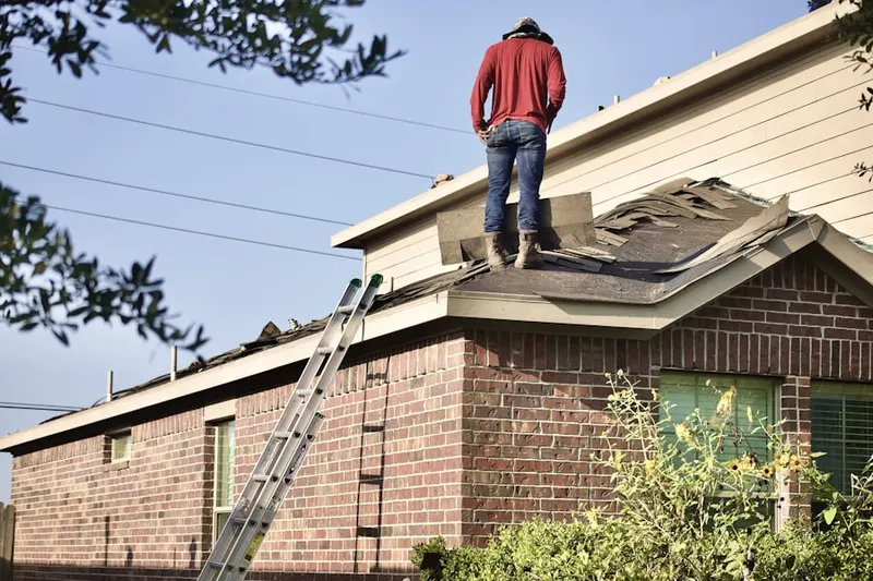 Professional roofer working on a residential roof in Del City